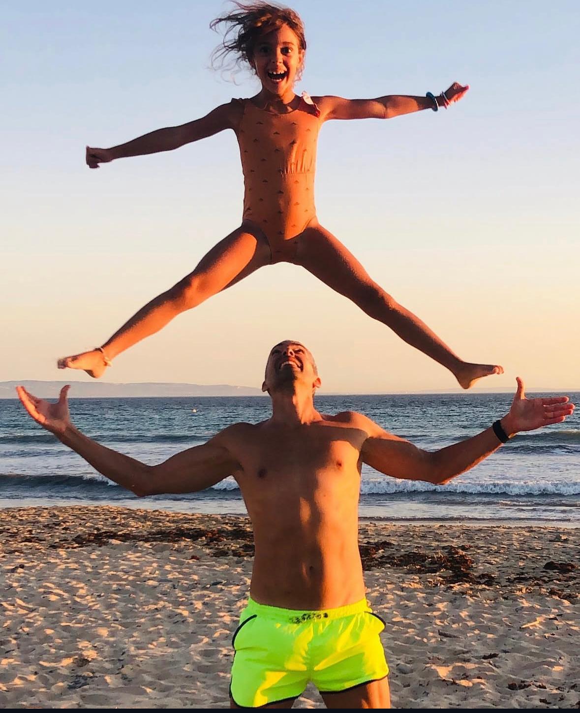 Familia disfrutando en la playa con autocaravana en Andalucía al atardecer